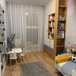 Aliaksandr Bortnik - Pokój dziecięcy po remoncie: drewniana podłoga, białe meble z akcentami szarości, ścianka wspinaczkowa i tapeta z motywem kosmosu. Jasne, przestronne wnętrze.