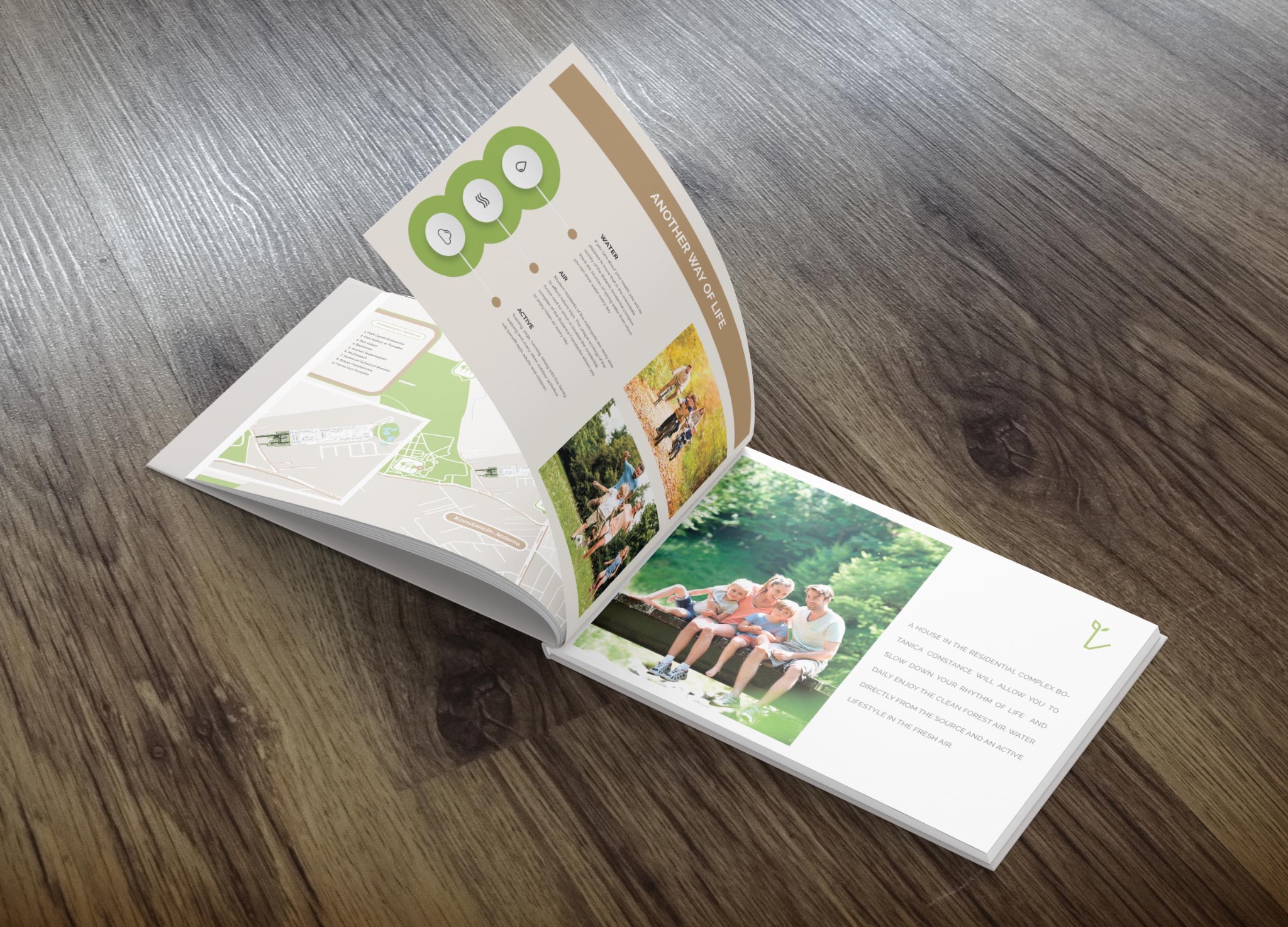 Otwarty katalog reklamowy leżący na drewnianej powierzchni, prezentujący wizualizacje osiedla mieszkaniowego z hasłami o zdrowym stylu życia.