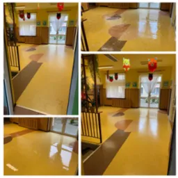 Żółta, błyszcząca podłoga z wzorami w przedszkolu lub szkole po umyciu, widoczne odbicia światła i okien, dekoracje wiszące pod sufitem.