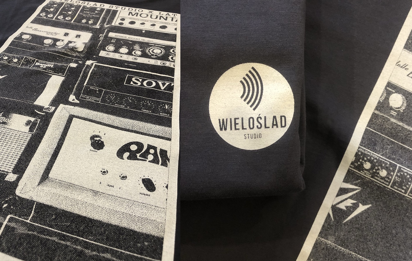 Ciemna koszulka z nadrukiem kolażu sprzętu audio (wzmacniacze, equalizery) w stylu retro oraz logo 'Wieloslad Studio' w białym okręgu.