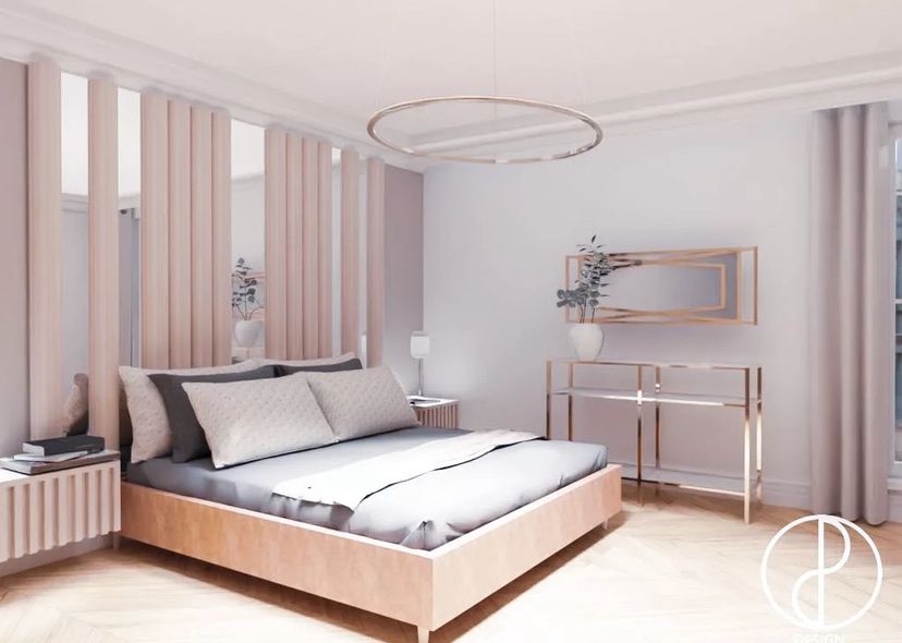 Jasna sypialnia w minimalistycznym stylu z drewnianym łóżkiem, szarą pościelą i dekoracyjną ścianką z pionowych paneli w odcieniach beżu. Okrągła lampa sufitowa i metalowa konsola z lustrem dodają...