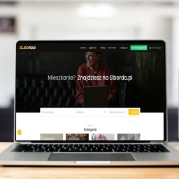 BSK Group - Bartłomiej Składanek - Laptop i smartfon prezentują stronę internetową Elbordo.pl na drewnianym biurku, z widocznym logo i interfejsem. Ekran laptopa jest głównym punktem skupienia.