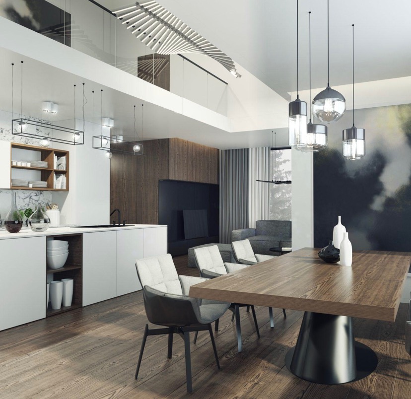 Nowoczesna kuchnia z białymi szafkami, drewnianym blatem i stołem jadalnym z drewnianym blatem wspartym na czarnej, okrągłej podstawie. Nad stołem wiszą szklane lampy. Na podłodze drewniane panele.