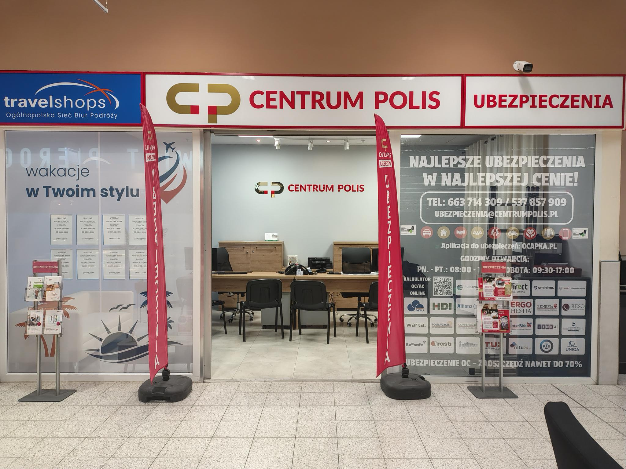 Biuro Centrum Polis Ubezpieczenia w Koninie. Widok na wejście z logo, flagi reklamowe i informacje o ofercie. Najlepsze ubezpieczenia w najlepszej cenie!