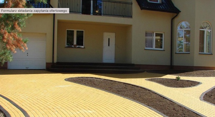 Żółta kostka brukowa ułożona przed domem w Lublinie, z wytyczonymi ścieżkami na rabaty kwiatowe.