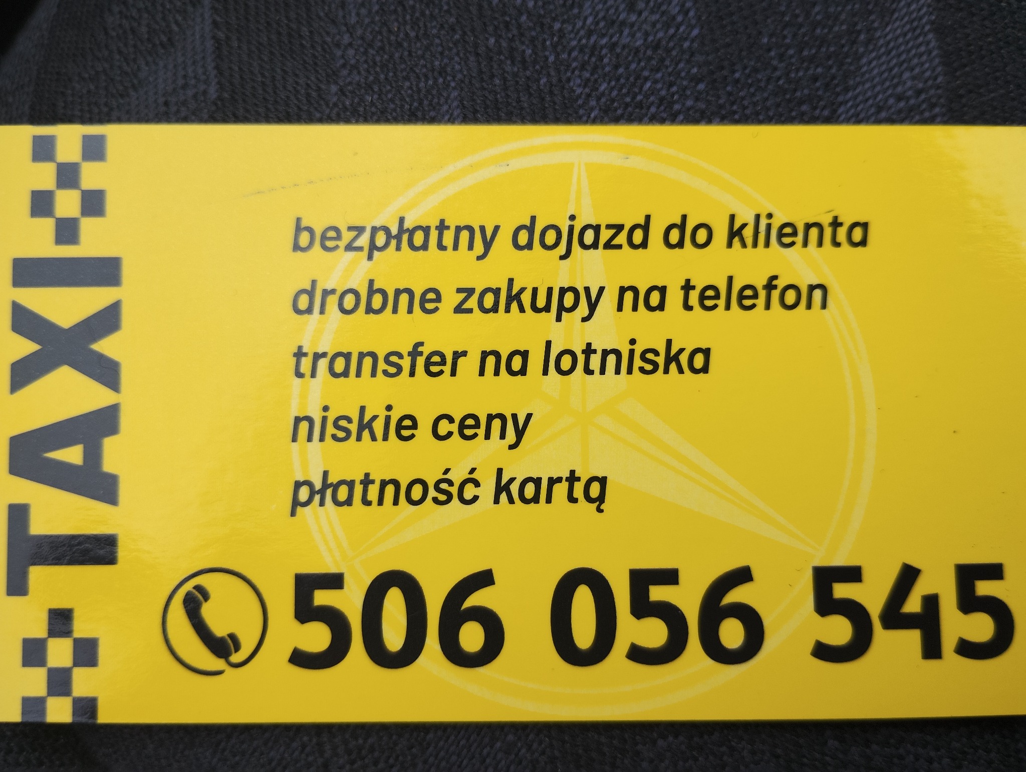 Żółta wizytówka taksówkarska z informacją o bezpłatnym dojeździe, drobnych zakupach na telefon, transferze na lotniska, niskich cenach i płatności kartą oraz numerem telefonu.