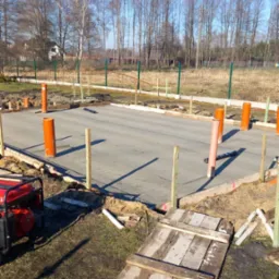 Przygotowany teren pod wylewkę fundament&oacute;w z deskowaniem, pionowymi rurami kanalizacyjnymi, agregatem prądotw&oacute;rczym i prowizorycznym drewnianym pomostem dla pieszych.