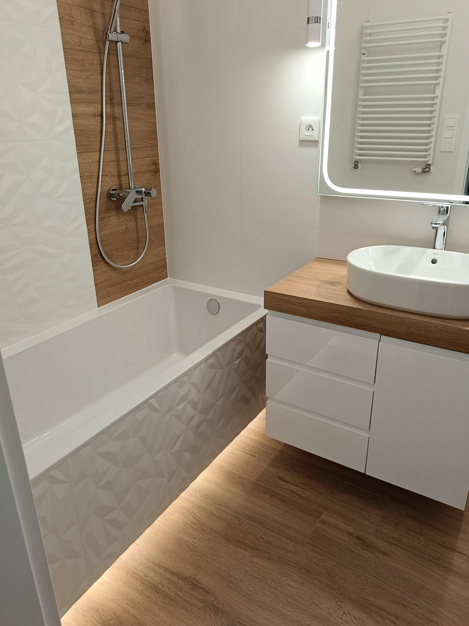 Bydgoszcz: Nowoczesna łazienka po remoncie. Umywalka nablatowa, bateria, lustro z podświetleniem LED, wanna z mozaiką 3D i armatura prysznicowa.