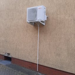 ARKOS - INSTAL ARKADIUSZ STENKA - Biała jednostka zewnętrzna pompy ciepła Viessmann zamontowana na beżowej elewacji budynku z widoczną instalacją odprowadzającą skropliny.