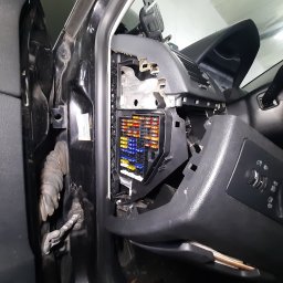 AUTO SERWIS KUBIAK PIOTR KUBIAK - Otwarty panel bezpieczników w samochodzie z widocznymi kolorowymi bezpiecznikami i elementami deski rozdzielczej.