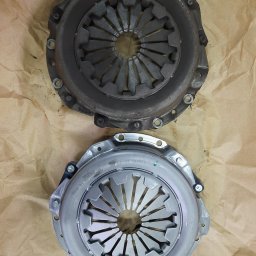 AUTO SERWIS KUBIAK PIOTR KUBIAK - Używane sprzęgło samochodowe obok nowego sprzęgła marki Valeo na brązowym papierze pakowym.