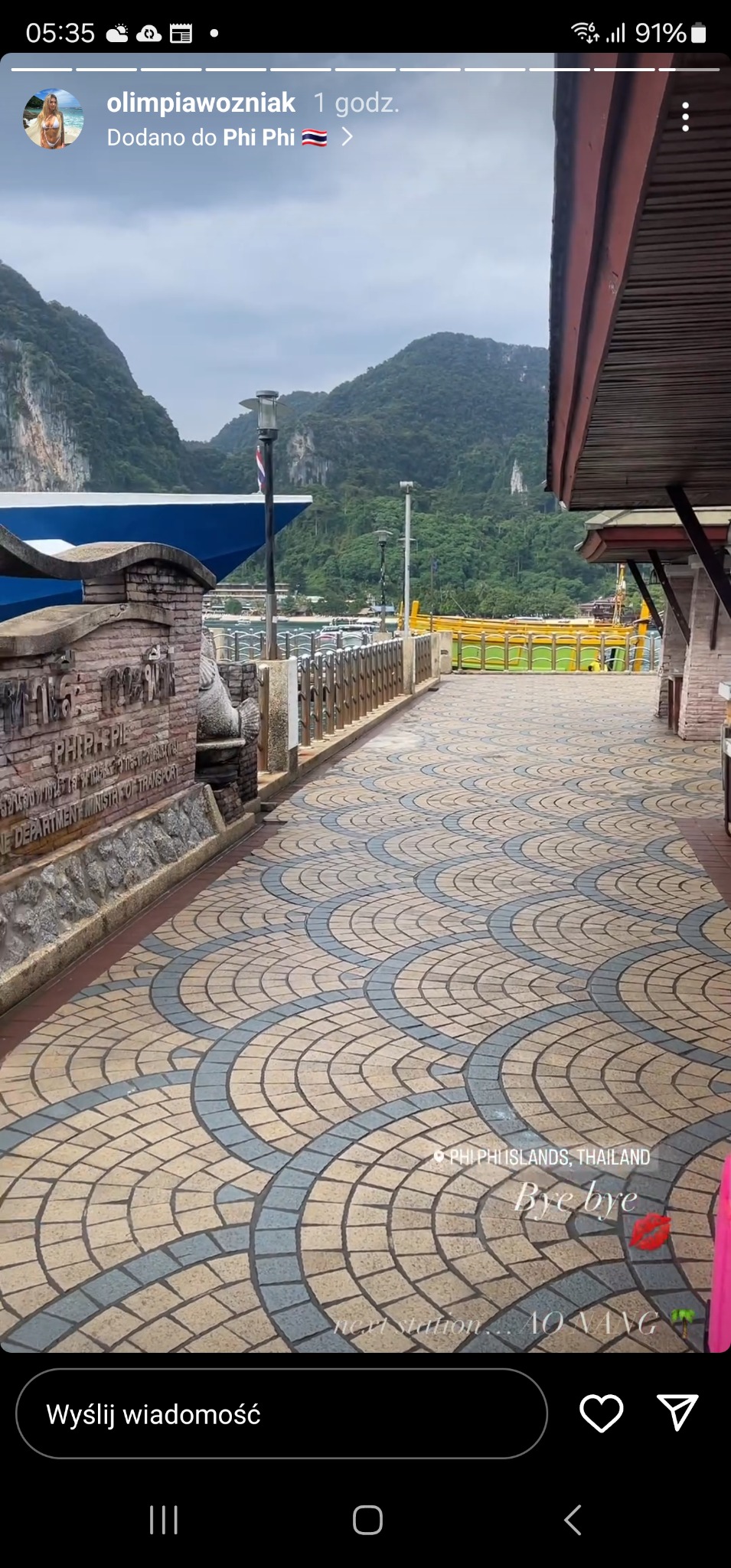 Wzorzysta nawierzchnia z kostki brukowej na promenadzie w Phi Phi Islands, Tajlandia, z widokiem na góry i morze w tle.