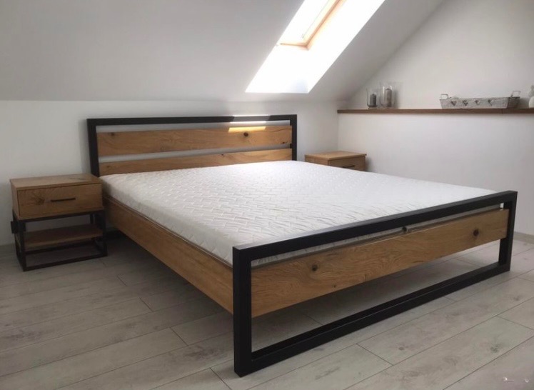 Drewniane łóżko z czarną, metalową ramą i szafkami nocnymi w pokoju na poddaszu z oknem dachowym i półką z dekoracjami. Widok z perspektywy podłogi.