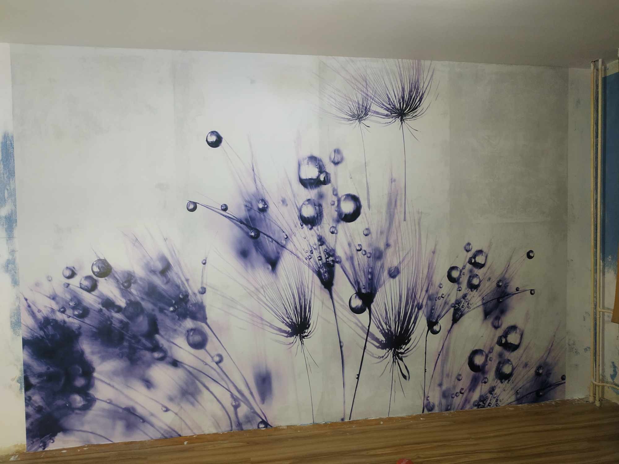 Ściana z tapetą w odcieniach fioletu przedstawiającą dmuchawce i krople wody, widoczny fragment drewnianej podłogi.