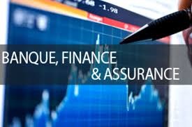 Wykres giełdowy na ekranie komputera z napisem 'BANQUE, FINANCE & ASSURANCE', częściowo zasłonięty przez czarny długopis.