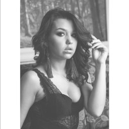 065 Leszek Hendzel - Portret kobiety w czarno-białej tonacji, z długimi kolczykami i delikatnym makijażem, pozującej na tle wzorzystej tapety imitującej las.