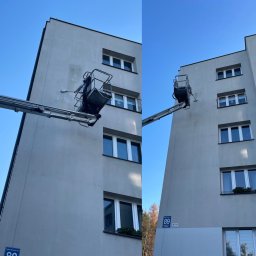 MK Clean Sp. z o.o. - Pracownik na podnośniku koszowym maluje elewację bloku mieszkalnego, widoczne ślady po czyszczeniu na ścianie, błękitne niebo w tle.