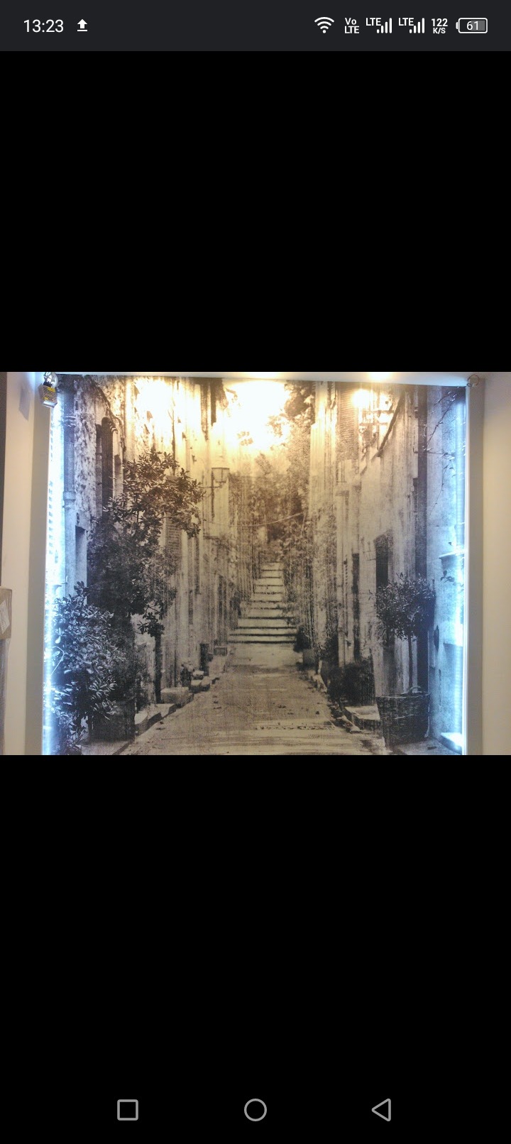 Fototapeta z podświetleniem LED prezentująca uliczkę w stylu śródziemnomorskim z roślinami w donicach.