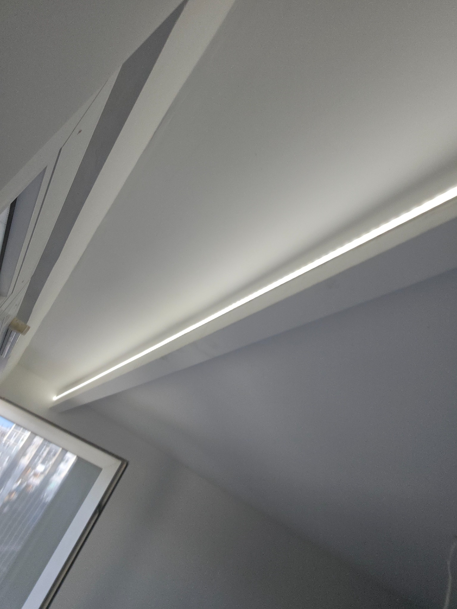 Wbudowane oświetlenie LED w suficie podwieszanym, widok z dołu, minimalistyczny design.