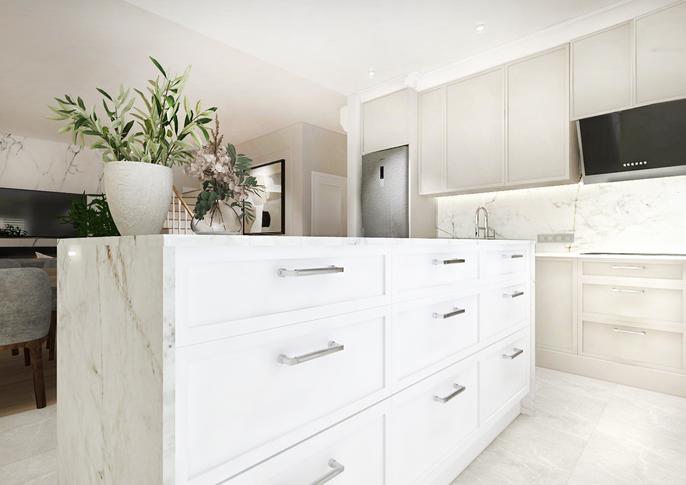 Jasna, nowoczesna kuchnia z wyspą o marmurowym blacie, białymi szafkami z podłużnymi uchwytami, kwiatami w wazonie i doniczce na blacie oraz marmurową ścianą nad blatem roboczym.