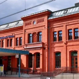 Odnowiony dworzec kolejowy Wałbrzych Główny z czerwonej cegły, widok z zewnątrz, zadaszone wejście, czyste okna i odświeżona elewacja.