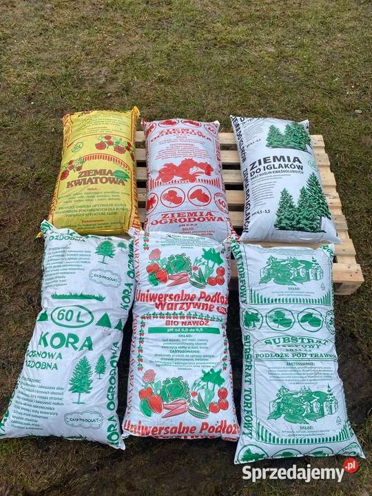 Paleta z workami ziemi ogrodowej, kory i substratu torfowego. Różne rodzaje podłoża: do kwiatów, iglaków, warzyw i trawników. Produkty ogrodnicze na zewnątrz.