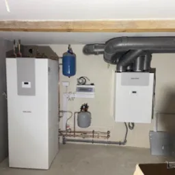 Zainstalowana rekuperacja Stiebel Eltron z kanałami wentylacyjnymi i pompa ciepła Stiebel Eltron w pomieszczeniu technicznym z widocznymi elementami instalacji hydraulicznej.