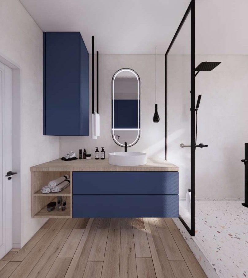 Nowoczesna łazienka z granatowymi szafkami, okrągłą umywalką nablatową, podświetlanym lustrem w czarnej ramie, kabiną prysznicową typu walk-in z czarnymi elementami i drewnianą podłogą.