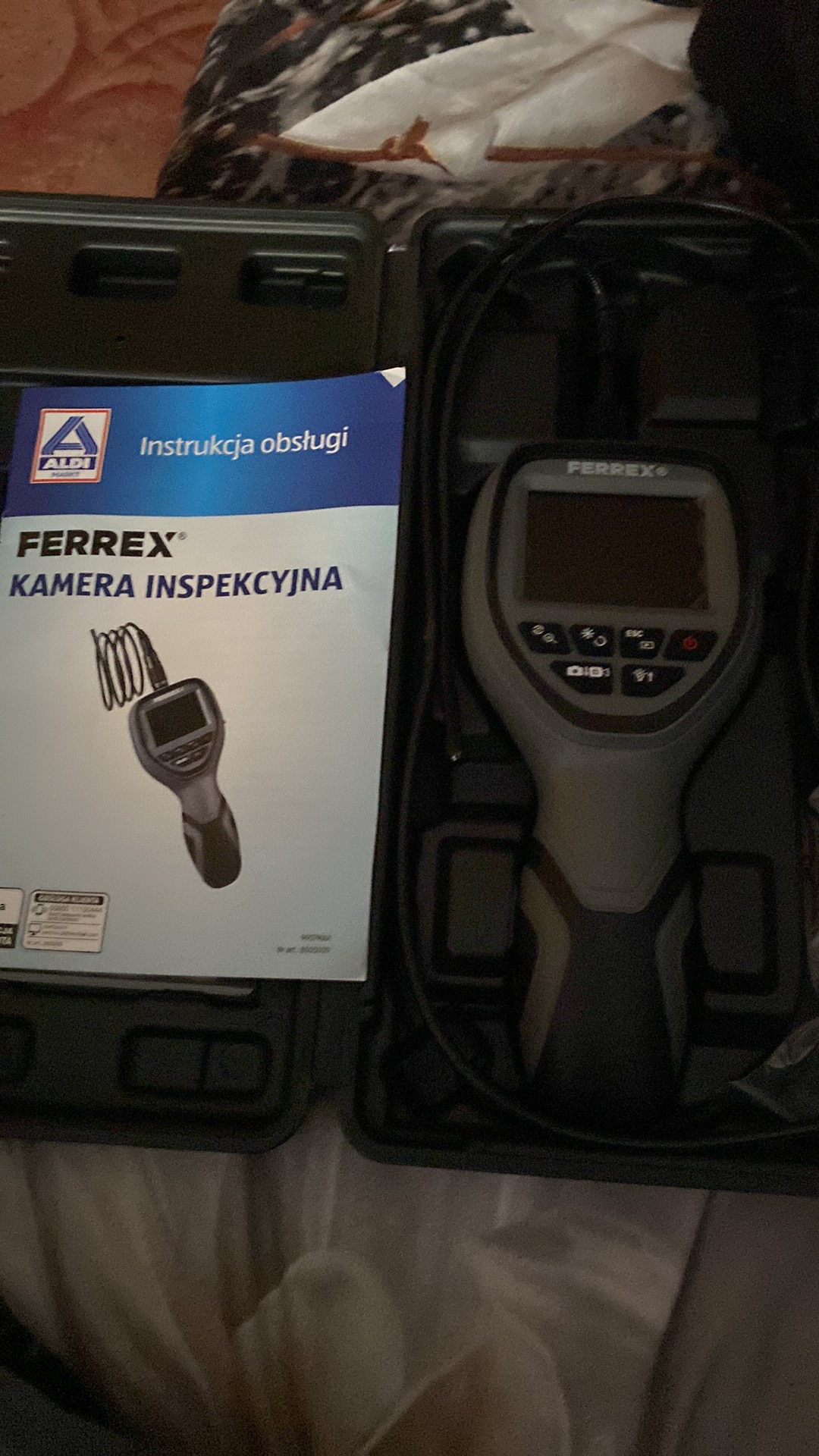 Kamera inspekcyjna Ferrex w walizce z instrukcją obsługi, widoczne przyciski i ekran urządzenia.