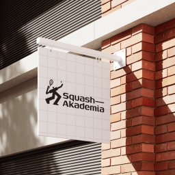 MIXTURE MARKETING SPÓŁKA Z OGRANICZONĄ ODPOWIEDZIALNOŚCIĄ - Zewnętrzny szyld z logotypem Squash Akademia, umieszczony na ceglanej ścianie budynku.