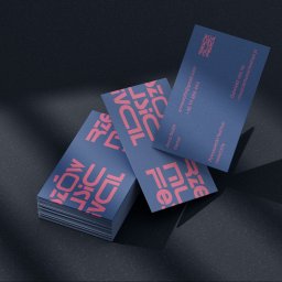 MIXTURE MARKETING SPÓŁKA Z OGRANICZONĄ ODPOWIEDZIALNOŚCIĄ - Stos wizytówek w kolorze granatowym z różowymi napisami, ułożonych na ciemnym tle z cieniem.