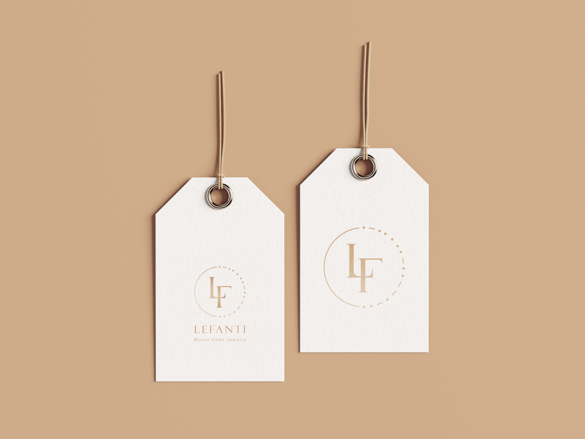 Dwie białe etykiety z logo 'LF' w okręgu, zawieszone na sznurkach na jednolitym, beżowym tle.