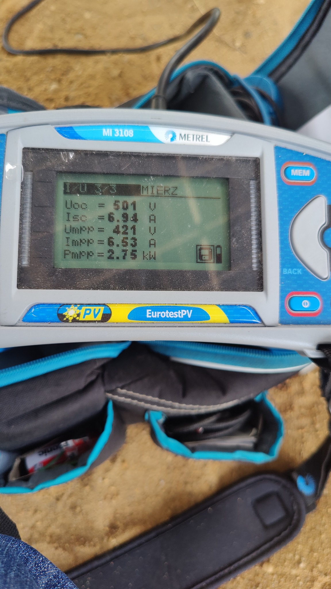 Miernik Metrel MI 3108 EurotestPV wyświetlający parametry instalacji fotowoltaicznej: Uoc 501V, Isc 6.94A, Umpp 421V, Impp 6.53A, Pmpp 2.75kW, leżący na torbie narzędziowej.