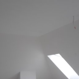 Usługi Remontowe i Wykończeniowe - Białe, świeżo pomalowane poddasze w Radomiu z oknami dachowymi i wystającym kablem ze ściany.