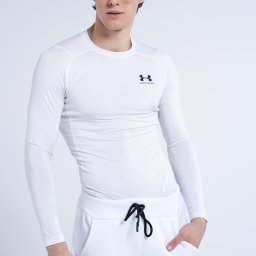 Aleksandra Linke - Młody mężczyzna w białym sportowym stroju Under Armour, pozujący na jasnym tle.