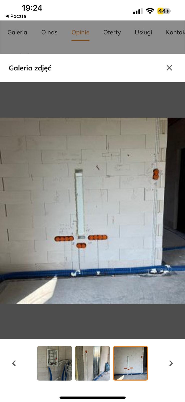 Ściana z betonu komórkowego z widocznymi puszkami instalacyjnymi i rurami instalacyjnymi w kolorze niebieskim. Instalacja elektryczna w trakcie realizacji.