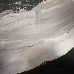 Quality House - Świeżo nałożona, mokra warstwa szarej masy szpachlowej na ścianie, widoczne ślady po pacy i nierówności powierzchni.