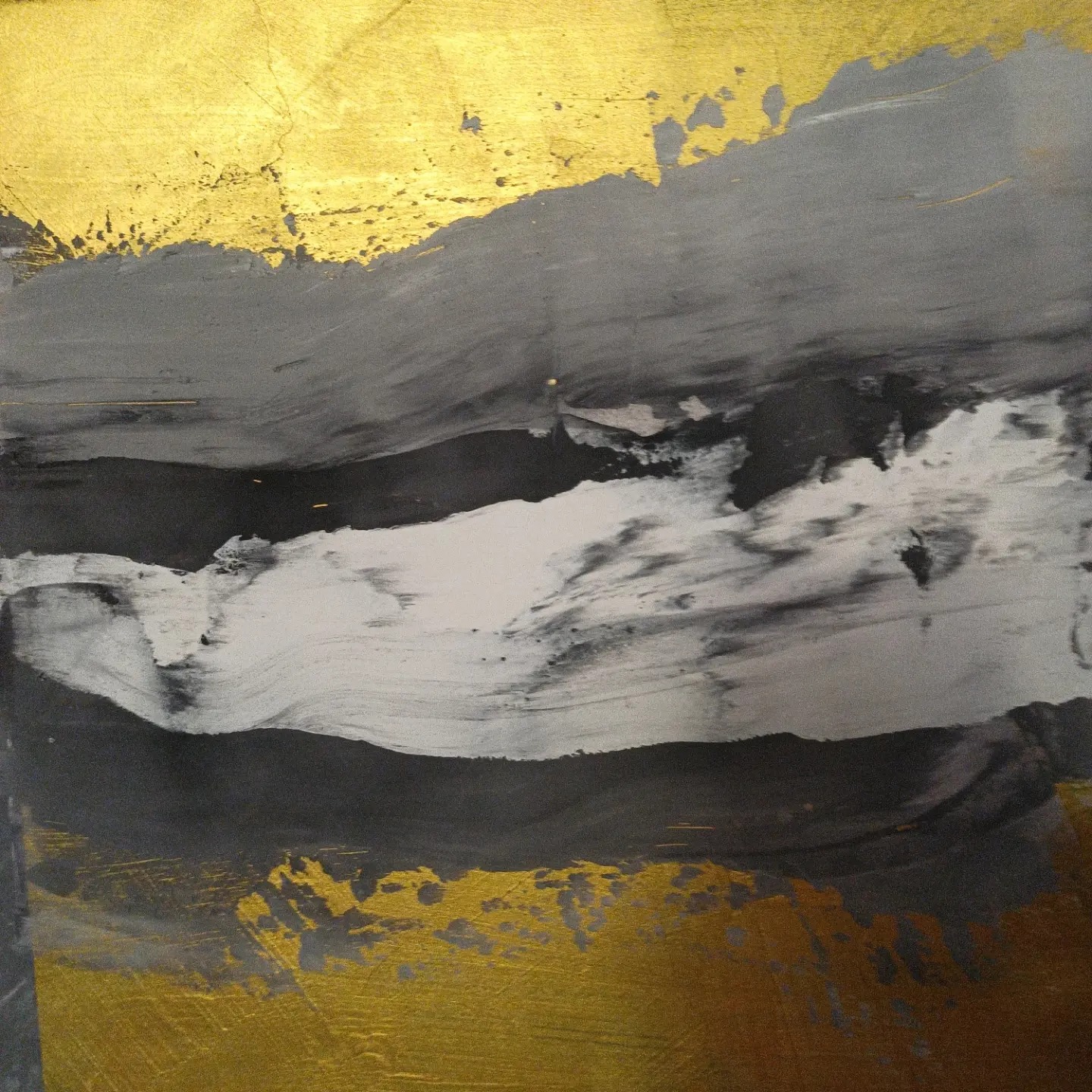 Abstrakcyjne malowanie ściany w Rykach z użyciem farb w odcieniach złota, szarości i czerni, tworzące nieregularne pasy i plamy.