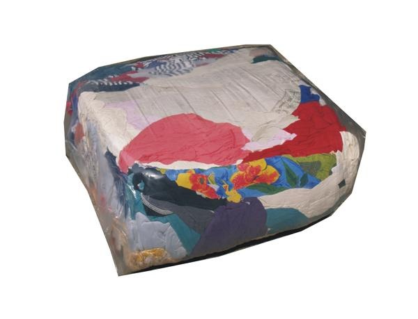 Sześcian sprasowanych, kolorowych ubrań zapakowany w przezroczystą folię.