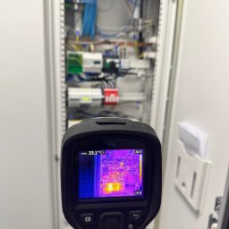 Twój Elektryk Tomek Usługi Elektryczne, Instalacje elektryczne, Awarie, Smart Home - Termowizja szafy elektrycznej: kontrola temperatury komponentów. Widoczne okablowanie, bezpieczniki i inne elementy. Diagnostyka instalacji elektrycznej w rozdzielnicy.