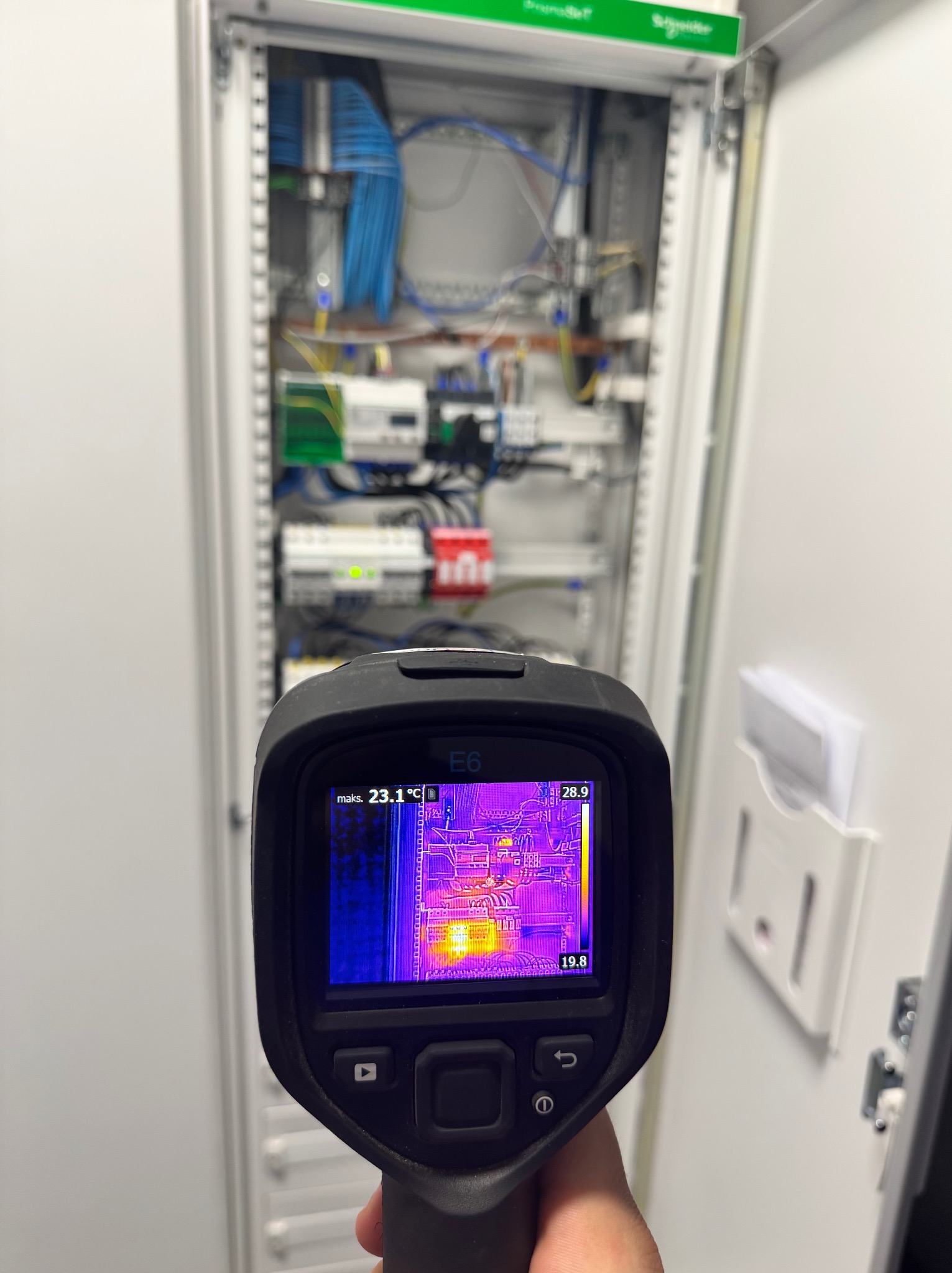 Termowizja szafy elektrycznej: kontrola temperatury komponentów. Widoczne okablowanie, bezpieczniki i inne elementy. Diagnostyka instalacji elektrycznej w rozdzielnicy.