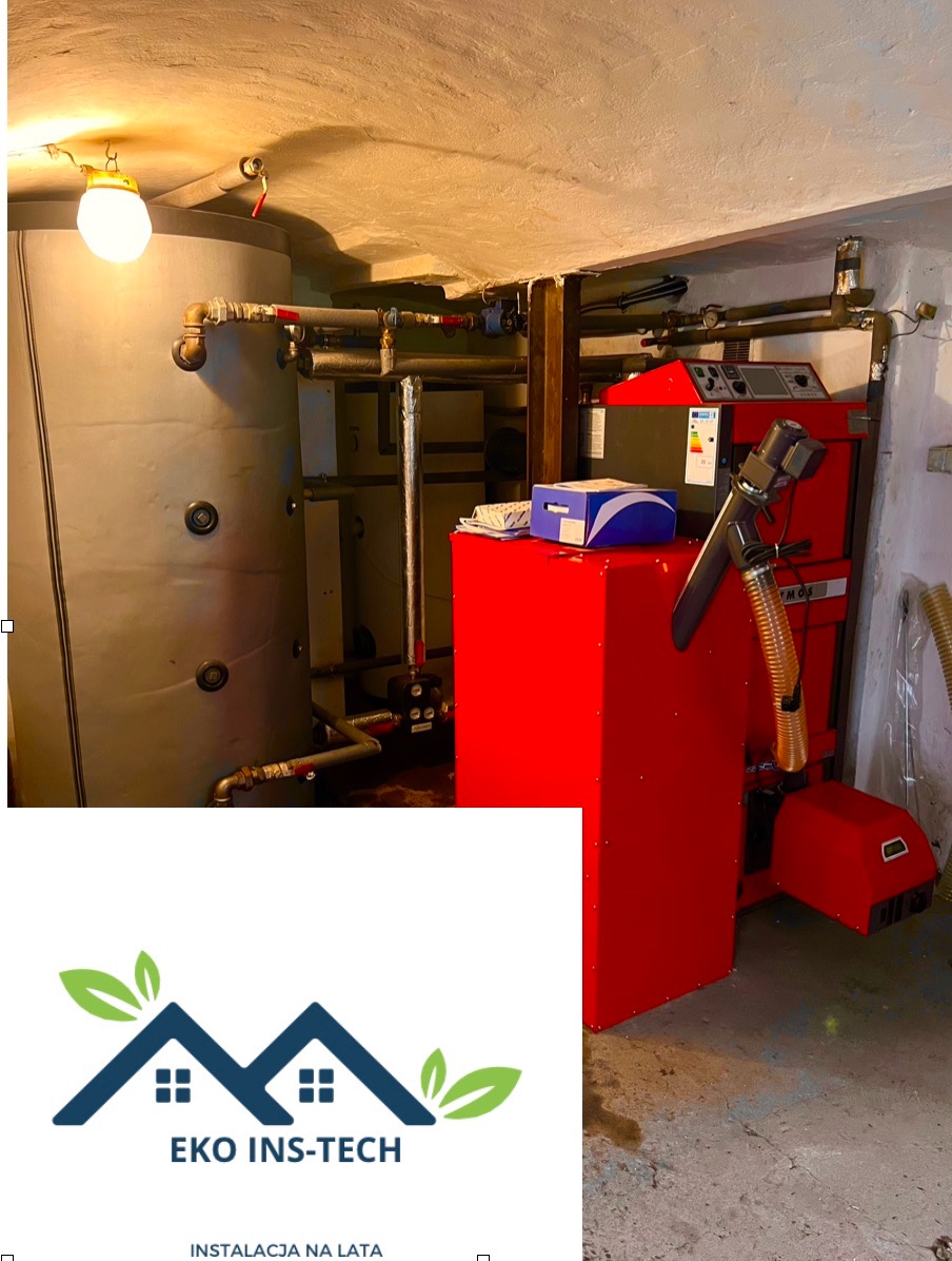Kotłownia z czerwonym kotłem na paliwo stałe, szarym zbiornikiem akumulacyjnym, instalacją hydrauliczną i logo firmy Eko Ins-Tech.