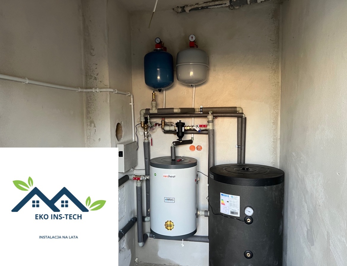 Zainstalowany zestaw zbiorników ciśnieniowych i podgrzewaczy wody w surowym pomieszczeniu, widoczne rury i armatura, logo firmy EKO INS-TECH w lewym dolnym rogu.
