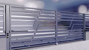 Nowoczesna brama przesuwna z metalowymi, poziomymi profilami o asymetrycznym układzie, wykończona w kolorze szarym, na tle jasnej elewacji.