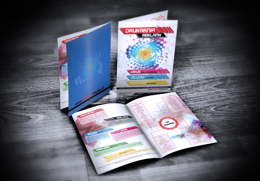 Katalog reklamowy otwarty na drewnianym tle, prezentujący ofertę drukarni z elementami identyfikacji wizualnej, w tym logo i hasła reklamowe.