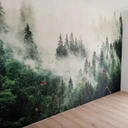 Fototapeta z motywem mglistego lasu iglastego na ścianie, widoczne gniazdka elektryczne z wystającymi kablami, jasna podłoga z paneli.