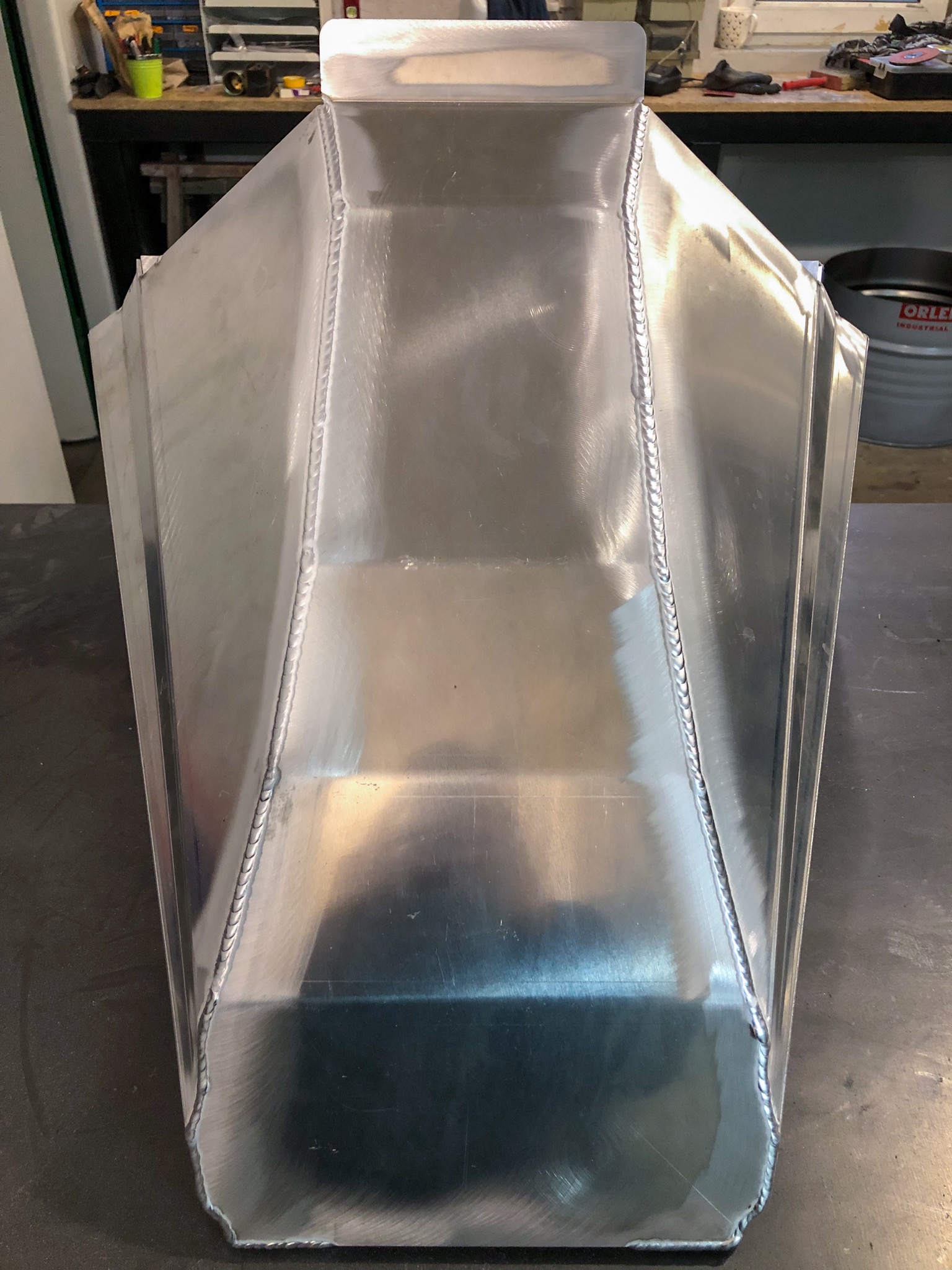 Konstrukcja ze spawanych, jasnych, metalowych płyt o trapezowym przekroju, widoczne spoiny i ślady obróbki powierzchni.