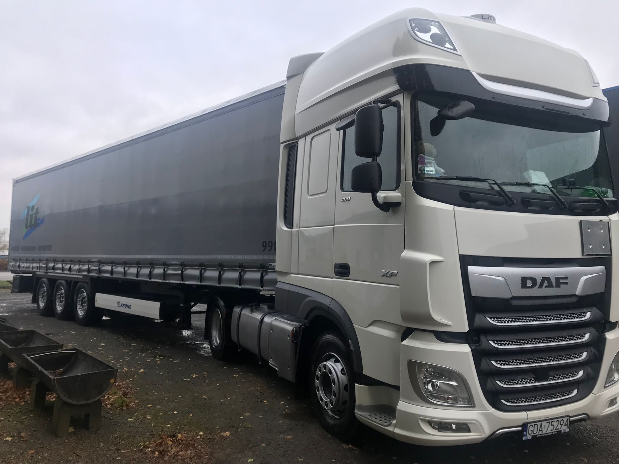 Biały ciągnik siodłowy DAF XF z naczepą marki Krone na parkingu, widoczna tablica rejestracyjna GDA 75294.