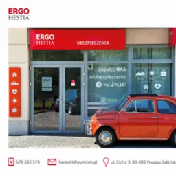 Biuro Ergo Hestia z czerwonym Fiatem 500 przed wejściem. Na szybach naklejki z ikonami: samochód, podróże, biznes, dom, zdrowie. Baner nad wejściem z napisem UBEZPIECZENIA.