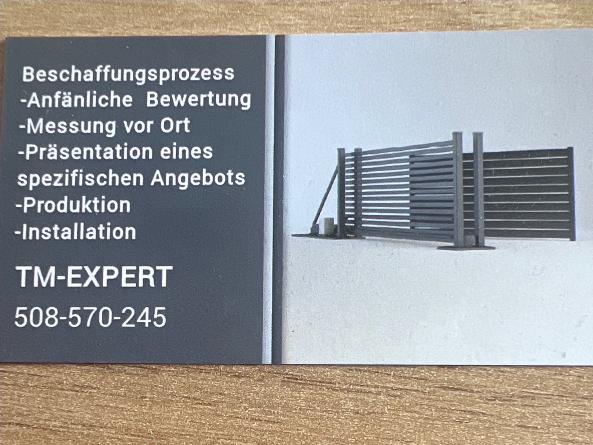 Wizytówka firmy TM-EXPERT prezentująca schematycznie ogrodzenie z poziomych paneli, obok tekst w języku niemieckim wymieniający etapy procesu: od wyceny, przez pomiar, prezentację oferty, produkcję...